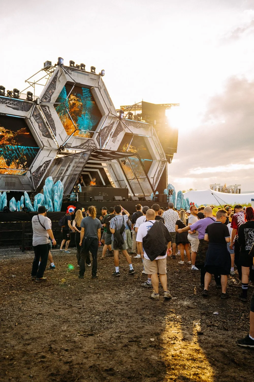 Lidé před pódiem na venkovním festivalu.